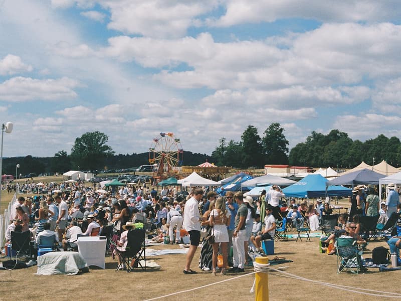 Visitors spread across the fairgrounds with the midway behind them